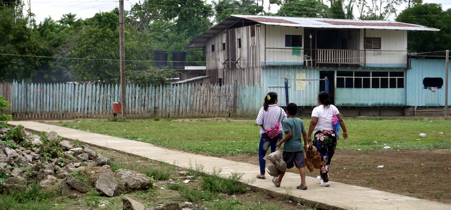 Tres personas caminando en una población indígena